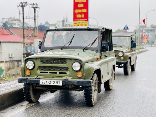 Classic military Jeep carrying tourists along the iconic streets of Hanoi