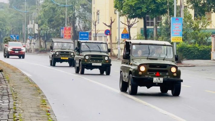 Classic military Jeep carrying tourists along the iconic streets of Hanoi