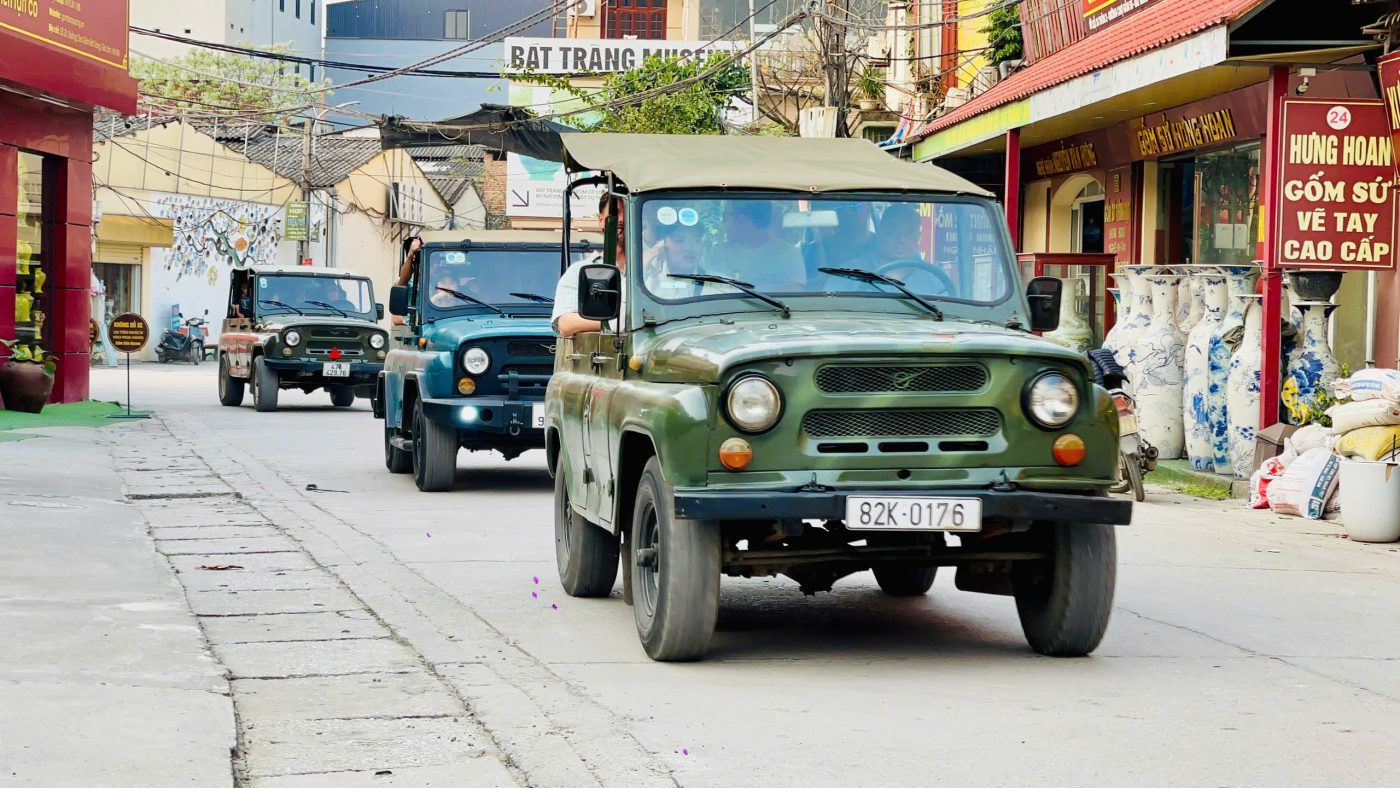 Tourists waving from Jeep on a Hanoi countryside adventure